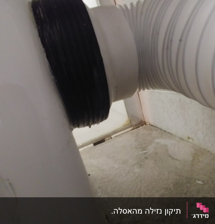 צינור פלסטיק מחובר לאסלה עם אטם שחור